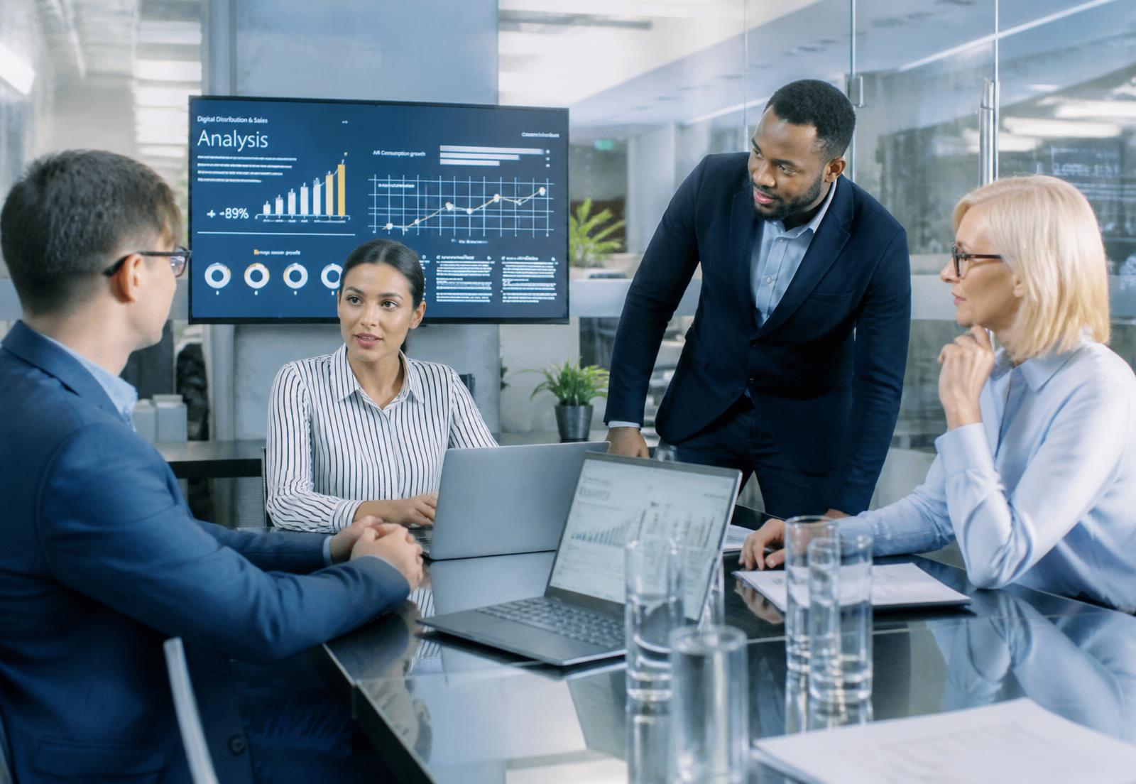Technology consultants reviewing business performance dashboards in a modern office